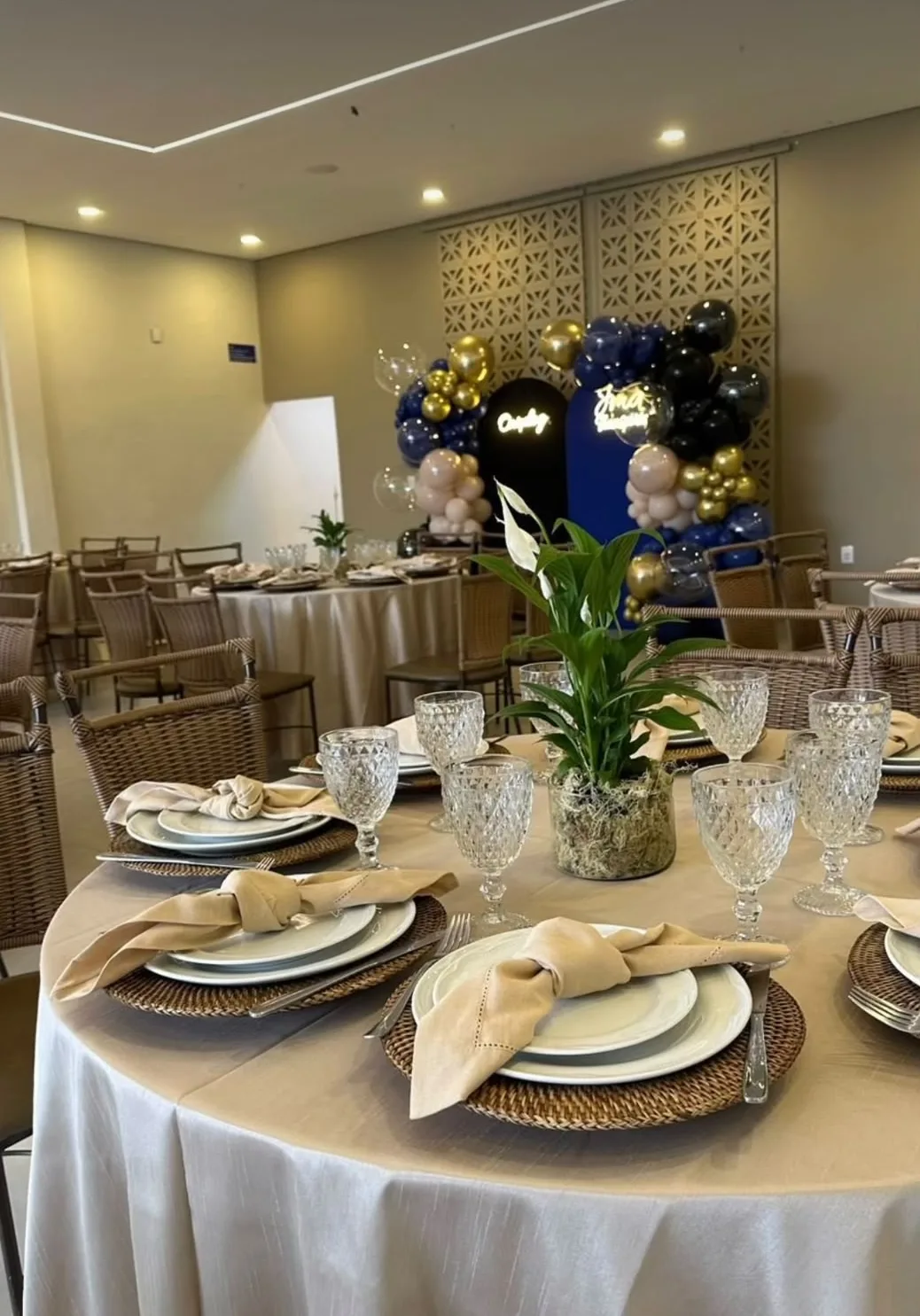 Mesas redondas decoradas com painel de balões no salão de festas Espaço Vila Maria